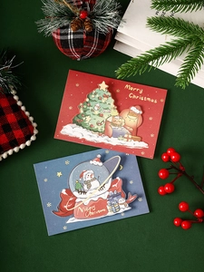 Detail of red and blue 3D Christmas cards with festive decor on a green background