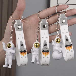 Astronaut keychain set with golden visors and white wrist straps on lunar motifs