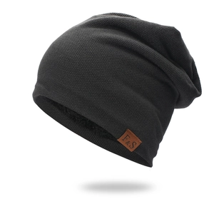 Dettaglio del berretto in maglia nera con spessa fodera in pile e toppa in pelle F&S