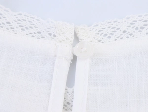 Macro detail of French lace trim and button closure on white cotton-linen set