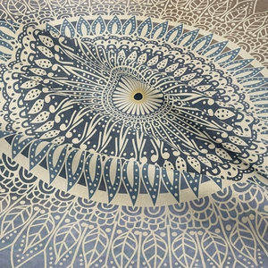 Bohemian mandala tapestry with intricate geometric patterns in blue and beige woven fabric