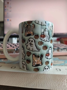 Detail of a green ceramic Halloween mug with spooky ghost and pumpkin illustrations