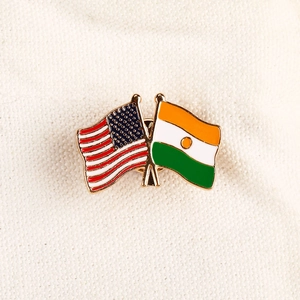 Épinglette croisée drapeaux USA et Niger avec bordure dorée et émail poli