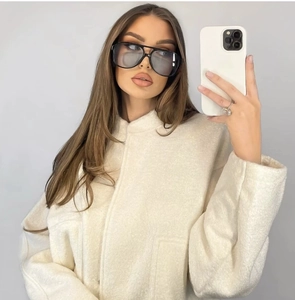 Detail of off-white sherpa jacket with stand collar and pocket shown in mirror selfie