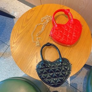 Detail of heart-shaped quilted jelly bags in red and black with gold chain straps