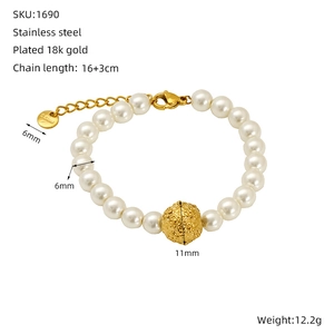 Détail d'un bracelet en perles et acier inoxydable plaqué or 18k avec breloque boule