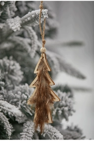 Close-up of wooden reindeer Christmas ornament with brown faux fur hanging on a snowy branch