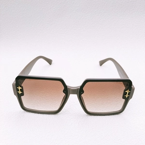 Macro shot of square gray sunglasses with brown gradient lenses and gold star detail