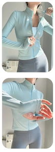 Détail d'une veste de sport zippée vert menthe à texture côtelée avec passe-pouces aux poignets