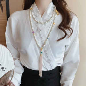 Detail of long pearl body chain with pink crystal tassel and multi-layer oriental design
