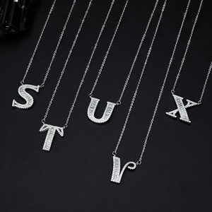Silver letter S T U V X necklaces with sparkling zircon crystals on black background