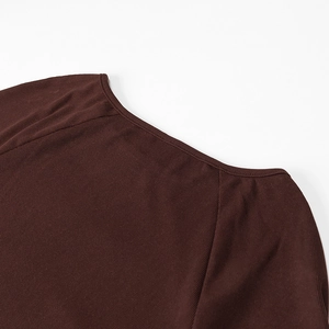 Dettaglio dello scollo e della spalla in maglia a coste marrone di un abito lungo aderente