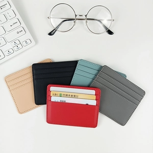 Detailed flat lay of slim leather card holders in five colors with office accessories