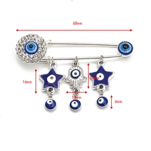 Detail view of 68mm silver Evil Eye safety pin brooch with Hamsa hand and star charms