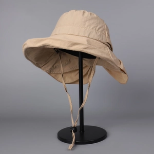 Macro detail of khaki sun hat with wide brim, adjustable drawstring and nylon fabric texture