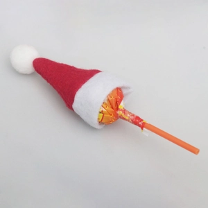 Close-up of a mini red and white felt Christmas hat decorating a round lollipop