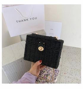 Detailaufnahme der schwarzen geflochtenen Box-Tasche mit Goldverschluss und Kette