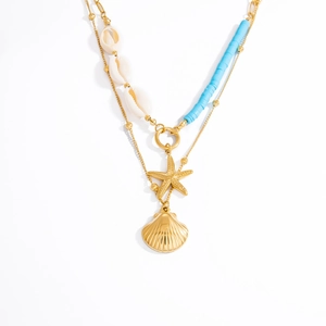 Detail of layered gold necklace with natural shell, starfish, and blue beads charms