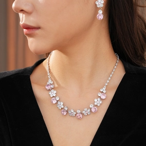 Detail of flower necklace and earrings set with pink and white cubic zirconia crystals