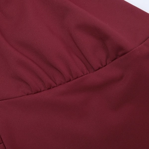 Detailed close-up of wine red fabric with fine pleated textures and premium stitching