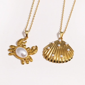 Colliers en acier titane doré avec pendentifs crabe et coquillage et détails perles