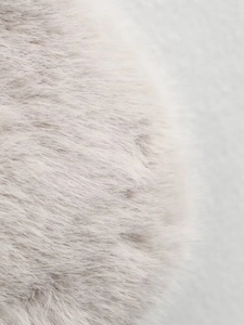Gros plan sur la texture fausse fourrure beige clair aux fibres douces et détails fins