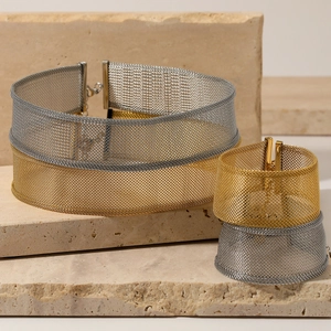 Minimalist mesh gold and silver necklace and bracelet set displayed on textured stone