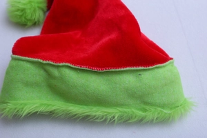 Detail of red velvet Christmas hat with fluorescent green faux fur trim texture