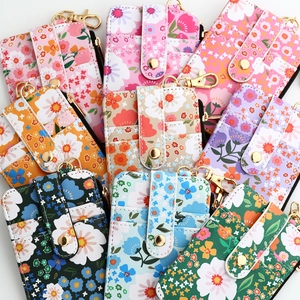 Floral print card holder wallets in multiple colors with gold zippers and hooks