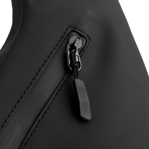 Detail of waterproof matte zipper and textured fabric on black tactical sling bag