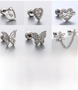 Détails macro des boucles d'oreilles en zircon argenté avec nœud et cœur en acier