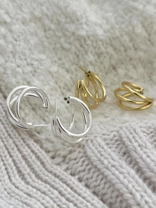 Detailed view of triple-layered geometric S925 silver hoop earrings in gold and silver