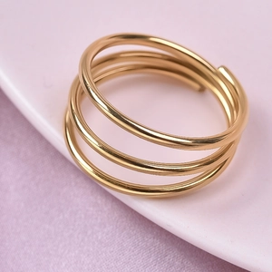 Detailed view of a gold triple-layer spiral stainless steel ring on a display stand