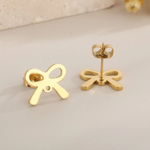 Macro shot of minimalist hollow bow earrings in brushed gold finish with metal backs