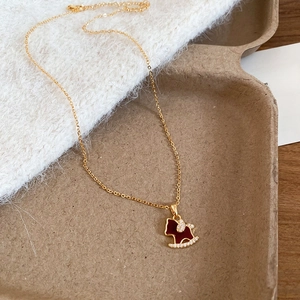 Detail of gold plated rocking horse necklace with red enamel and pavé zircon stones