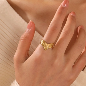 Fashionable V-shaped gold plated stainless steel open ring with textured surface on finger