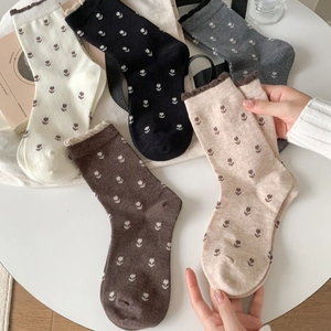 Vue détaillée de chaussettes en coton à motif floral en cinq couleurs dont blanc et noir
