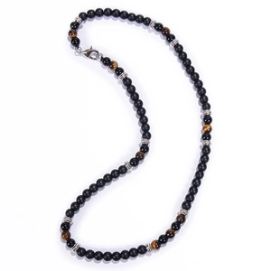 Detailed macro view of black matte beads and tiger eye stones necklace with silver spacers