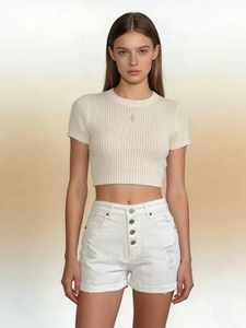 Detail of high-waisted white denim shorts with four buttons and ripped hem texture