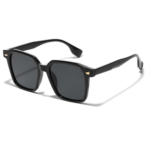 Oversized black square sunglasses for women with golden metal temple accents on a white background