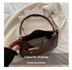 Detail view of the deep brown vintage shoulder bag showing spacious interior and golden hooks