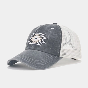 Close-up of vintage grey trucker hat with tribal embroidery and breathable white mesh