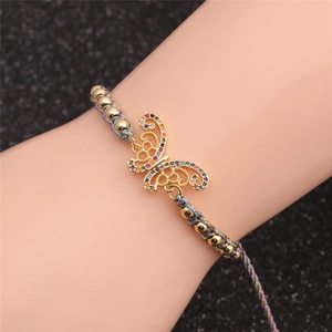 Detail of adjustable butterfly bracelet with colorful gemstones on gold beads on the wrist
