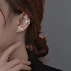 Detailed view of silver butterfly stud and ear cuff with sparkling zircon on a model