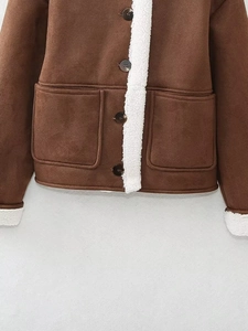Detail of brown suede jacket showing front pockets and white faux shearling trim