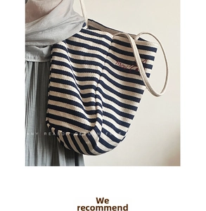 Detailed close-up of blue striped canvas tote bag featuring red embroidery and rope handle