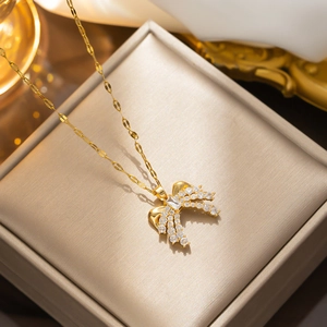 Elegant gold bow necklace with sparkling zircon crystals in a luxury jewelry box