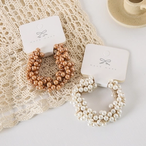 Handmade elastic pearl hair scrunchies in champagne gold and ivory on a paper card