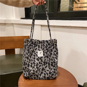 Close-up of leopard print corduroy tote bag showing soft texture and sturdy strap details