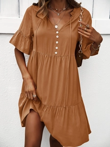 Détail de robe trapèze marron avec col en V, manches à volants et liens à nouer